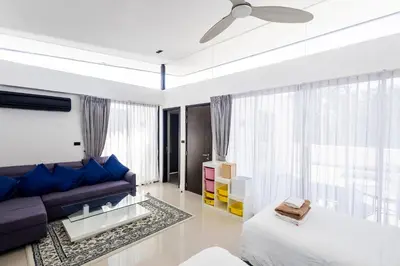 a living room with a purple couch and a window at Villa Laguna Park in Ban Thalat Choeng Thale