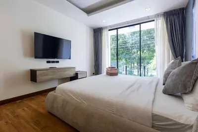 a bedroom with a large bed and a large window at Villa Laguna Park in Ban Thalat Choeng Thale