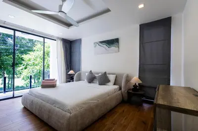 a bedroom with a bed and a large window at Villa Laguna Park in Ban Thalat Choeng Thale