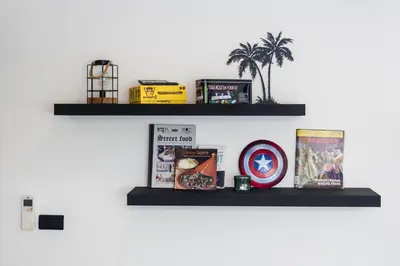 a shelf on a wall with books and other items at Villa Laguna Park in Ban Thalat Choeng Thale