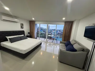 a bedroom with a bed and a couch and a television at Smily Phuket Patong Sea View in Patong Beach
