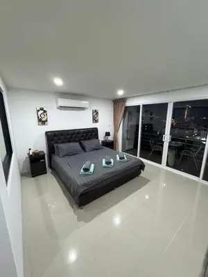 a bedroom with a large bed and a balcony at Smily Phuket Patong Sea View in Patong Beach
