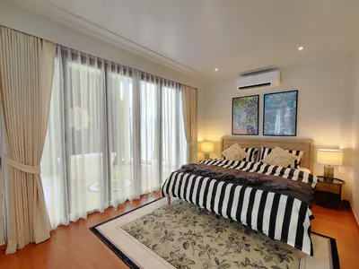 a bedroom with a bed and a large window at Golden Andes \u8c6a\u534e\u5ea6\u5047\u522b\u5885 in Ban Mut Dok Khao