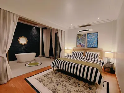 a bedroom with a large bed and a bath tub at Golden Andes \u8c6a\u534e\u5ea6\u5047\u522b\u5885 in Ban Mut Dok Khao
