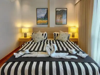 two swans made out of towels on a bed at Golden Andes \u8c6a\u534e\u5ea6\u5047\u522b\u5885 in Ban Mut Dok Khao
