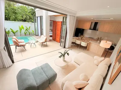 a living room with a couch and a table and a kitchen at Golden Andes \u8c6a\u534e\u5ea6\u5047\u522b\u5885 in Ban Mut Dok Khao