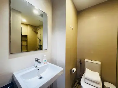 a bathroom with a sink and a toilet and a mirror at Cozy studio 1 bdr Golf view in Laguna Phuket