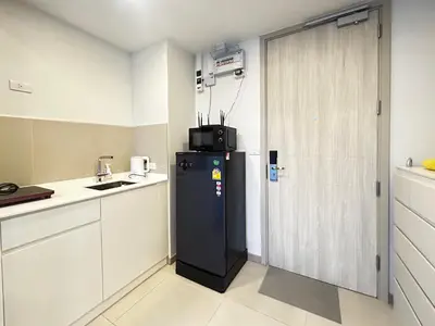 a small kitchen with a refrigerator and a window at Cozy studio 1 bdr Golf view in Laguna Phuket