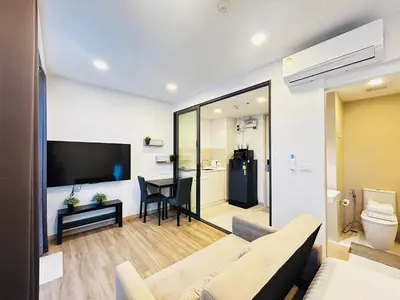 a living room with a couch and a tv and a table at Cozy studio 1 bdr Golf view in Laguna Phuket