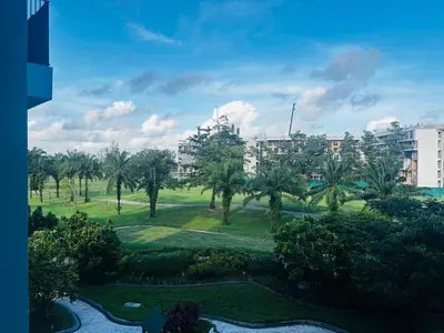 a view of a park with palm trees and buildings at Cozy studio 1 bdr Golf view in Laguna Phuket