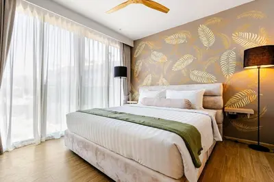 a bedroom with a large bed and a large window at Beachside by Villacarte in Bang Tao Beach