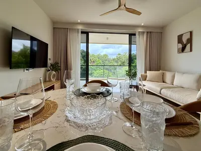 a living room with a table with wine glasses on it at Beachside by Villacarte in Bang Tao Beach