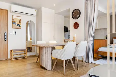 a dining room and living room with a table and chairs at Beachside by Villacarte in Bang Tao Beach