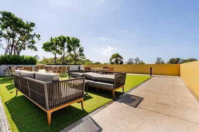 a patio with chairs and tables on the grass at Beachside by Villacarte in Bang Tao Beach
