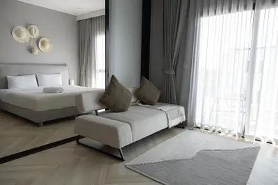 a bedroom with a bed and a couch and a chair at The Legendary Bang Tao 1-bedroom apart #711 in Bang Tao Beach