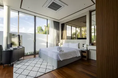 a bedroom with a bed and a large window at Villa The Ozone in Ban Thalat Choeng Thale