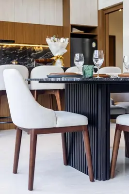 a table with a white chair and wine glasses at Villa The Ozone in Ban Thalat Choeng Thale