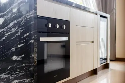 a kitchen with a black oven in a cabinet at Villa The Ozone in Ban Thalat Choeng Thale