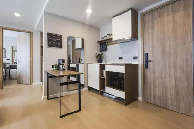 a room with a kitchen with a counter and a table at The SPACE Apartment 612 in Ban Thalat Choeng Thale