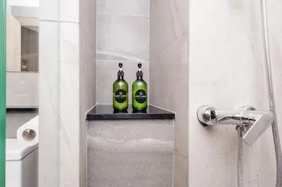 two bottles of wine sitting on a shelf in a bathroom at The SPACE Apartment 614 in Ban Thalat Choeng Thale