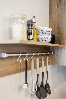 a row of utensils hanging on a shelf at The SPACE Apartment 614 in Ban Thalat Choeng Thale