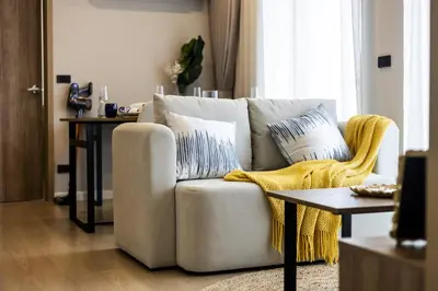 a living room with a couch and a table at The SPACE Apartment 614 in Ban Thalat Choeng Thale