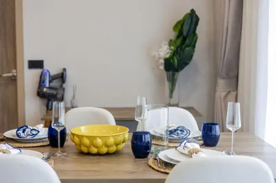 a dining room table with a yellow bowl and wine glasses at The SPACE Apartment 614 in Ban Thalat Choeng Thale
