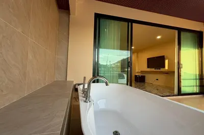 a bath tub in a bathroom with a television at Sand Maré Karon Hotel in Karon Beach