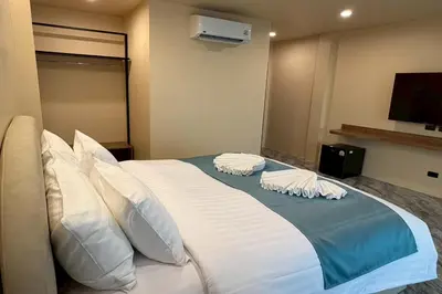 a bedroom with a large bed with white pillows at Sand Maré Karon Hotel in Karon Beach
