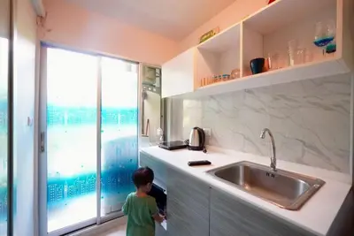 a little boy standing in a kitchen with a sink at Valley Mountain ViewCity Proximity Golden Eight Apartment in Phuket Town
