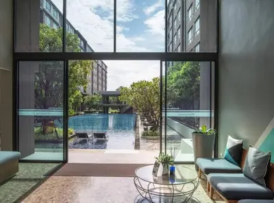 a living room with a view of a pool through windows at Valley Mountain ViewCity Proximity Golden Eight Apartment in Phuket Town