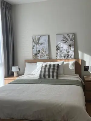 a bedroom with a large bed with two pictures on the wall at Sun Sea Sand in Thalang