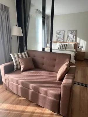 a couch in a living room with a bed at Sun Sea Sand in Thalang
