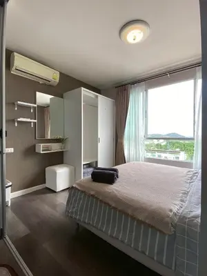 a bedroom with a bed and a large window at Nassaree Condo in Phuket Town