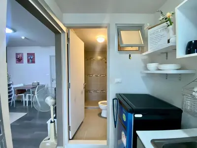 a small kitchen with a sink and a toilet at Nassaree Condo in Phuket Town