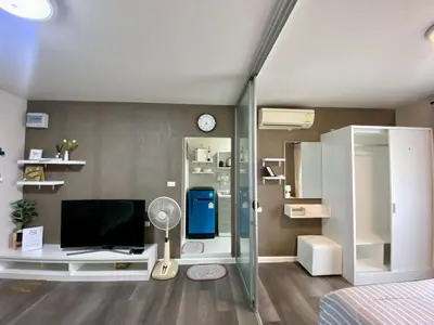 a bedroom with a desk with a tv and a mirror at Nassaree Condo in Phuket Town