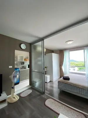 a bedroom with a bed and a glass wall at Nassaree Condo in Phuket Town