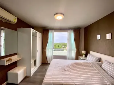 a bedroom with a large bed and a window at Nassaree Condo in Phuket Town