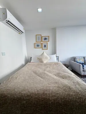 a bedroom with a large bed and a chair at 1 Bedroom close to Central Shopping Mall in Ban Rangeng