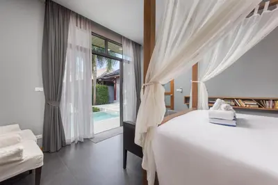 a bedroom with a white bed and a window at Villa Kiana 2BR Private Pool 10 min to Nai Harn in Ban Saiyuan (1)