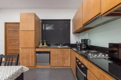 a kitchen with wooden cabinets and a counter top at Villa Kiana 2BR Private Pool 10 min to Nai Harn in Ban Saiyuan (1)
