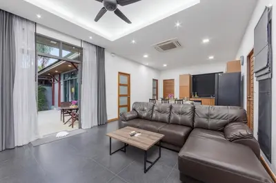 a living room with a leather couch and a table at Villa Kiana 2BR Private Pool 10 min to Nai Harn in Ban Saiyuan (1)