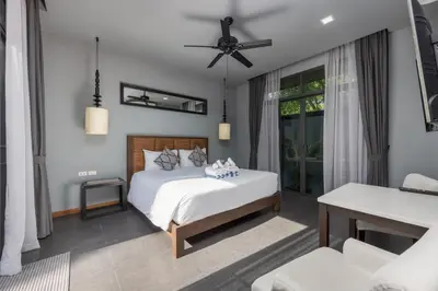 a bedroom with a bed and a living room at Villa Kiana 2BR Private Pool 10 min to Nai Harn in Ban Saiyuan (1)