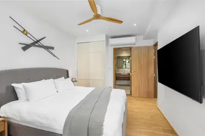 a bedroom with a bed and a flat screen tv at Laguna BeachSide Bang Tao by My Home Phuket in Bang Tao Beach