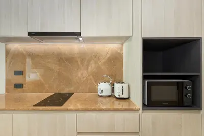 a kitchen with a counter with a microwave and a stove at Ozone condominium Bang Tao by My Home Phuket in Laguna Phuket