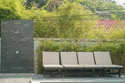 a row of white benches sitting next to a brick wall at Villa Heaven - Peaceful 3 Bedroom Private Pool Villa in Ban Kata