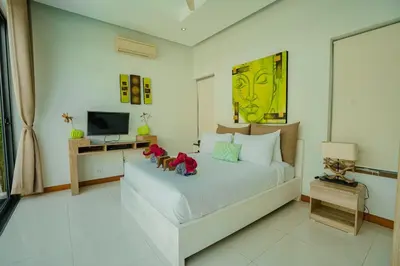 a bedroom with a bed with two stuffed animals on it at Villa Heaven - Peaceful 3 Bedroom Private Pool Villa in Ban Kata