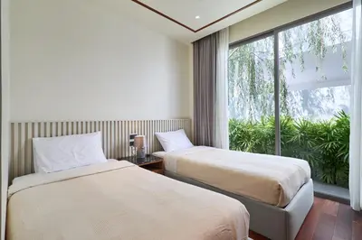 two beds in a room with a large window at Villa the Ozone Bang Tao by My Home Phuket in Laguna Phuket