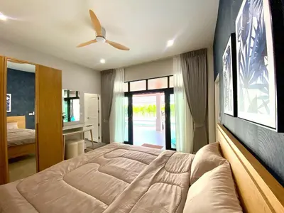a bedroom with a large bed with a ceiling fan at Baanthai villa Rawai in Rawai Beach