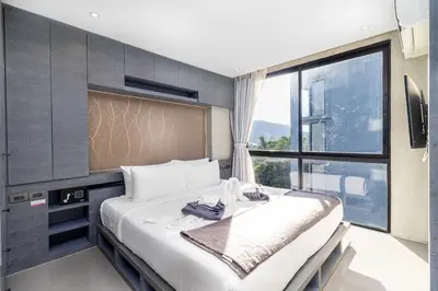 a bedroom with a large bed with a large window at C255 Best Stay Experience Condo with Full Facilities in Kamala Beach